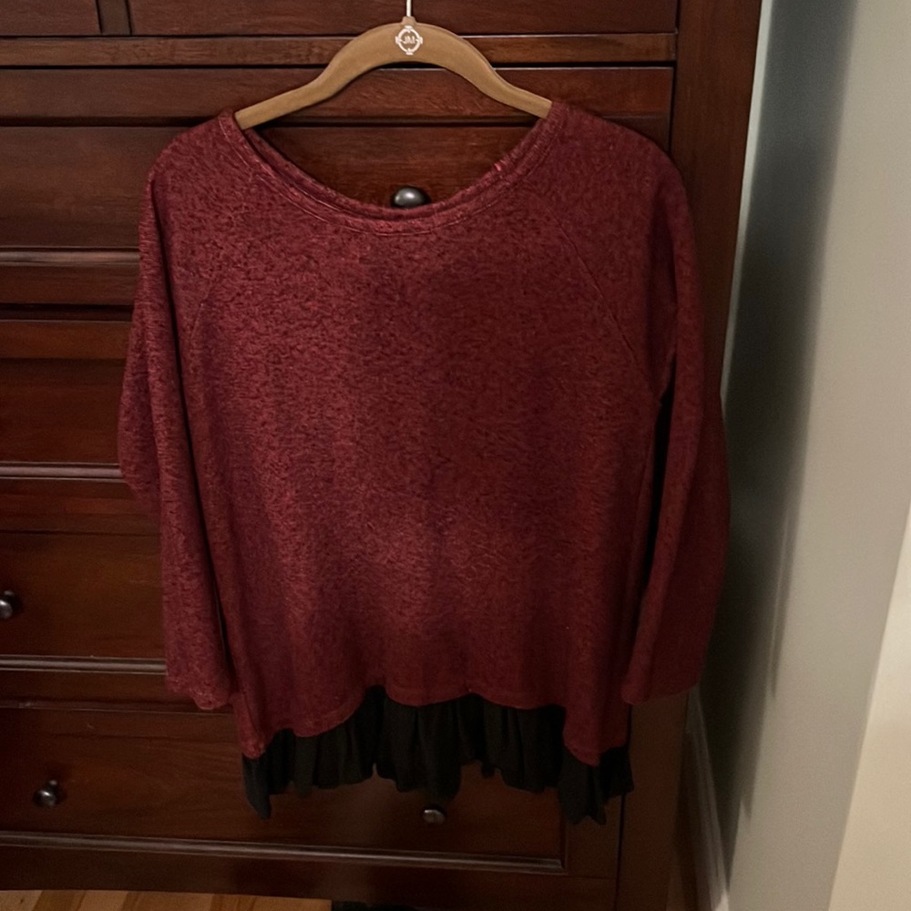 Red tunic with black ruffle details at the bottom. Black insert ribbon at back.